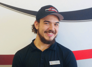 A man wearing a baseball cap and smiles at the camera.