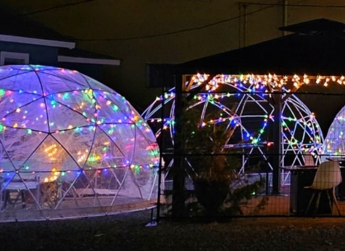 A bunch of igloos with Christmas lights on them.