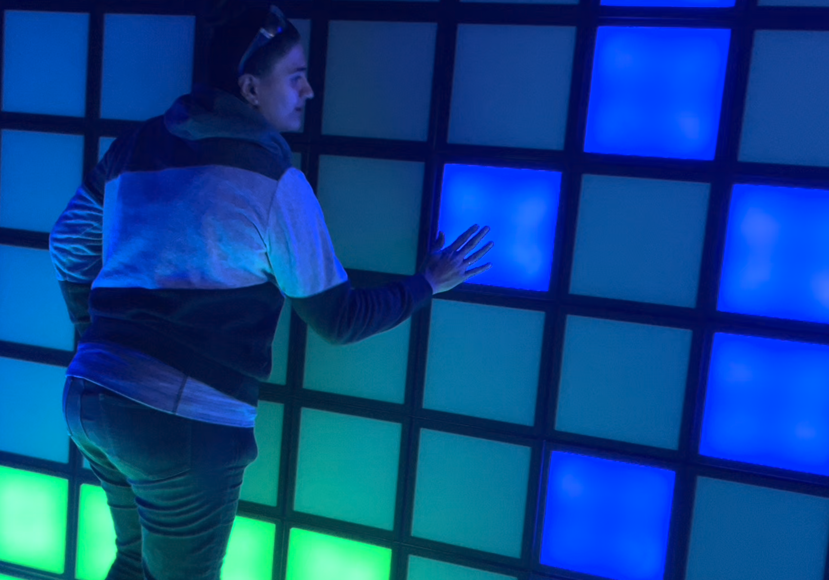 A woman pressing light-up, coloured tiles.