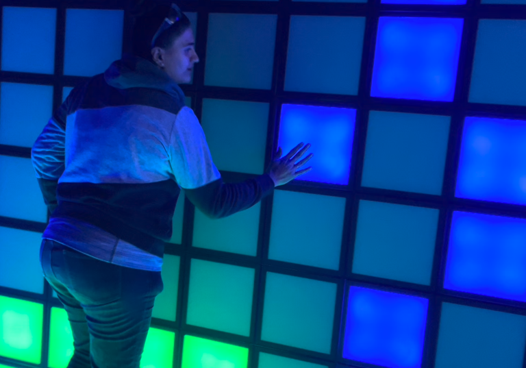 A woman pressing light-up, coloured tiles.