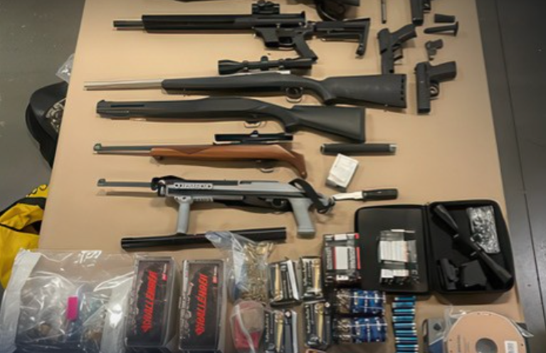 Guns and bullets laid out on a table.