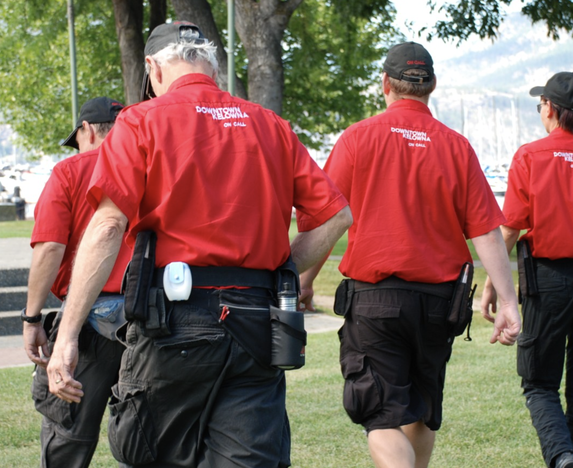 Four guys in red shirts walking in a line.
