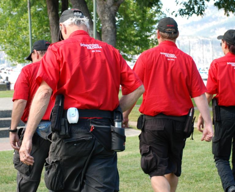Four guys in red shirts walking in a line.