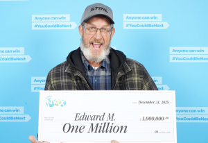 An excited man holding a big check.