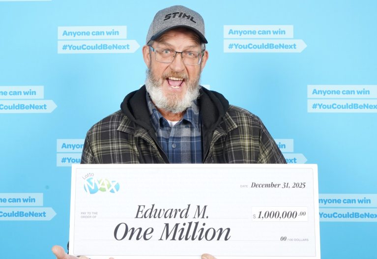An excited man holding a big check.