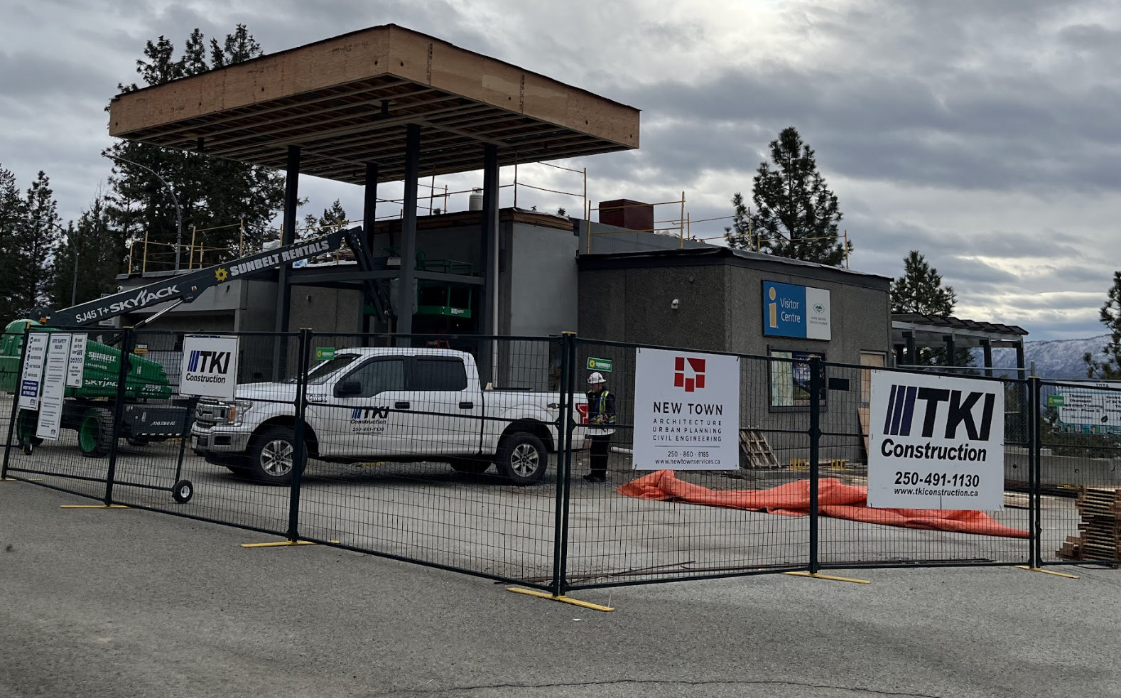 A construction site with a fence and a pickup truck.