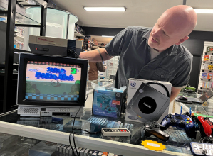 A man showing off Super Mario Bros. on NES.