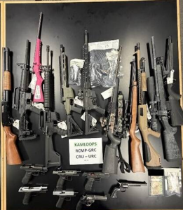 A collection of fire arms on a table.