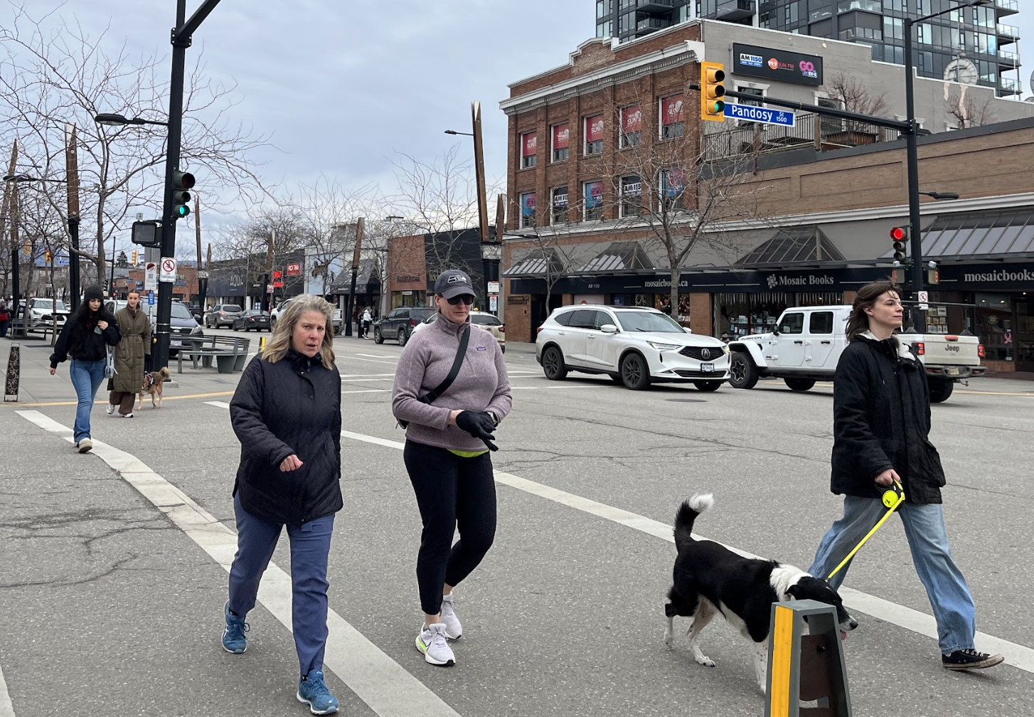 People crossing the street in front of Mosaic Books.