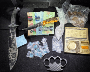 Knives, brass knuckles, some cash and some baggies of drugs.