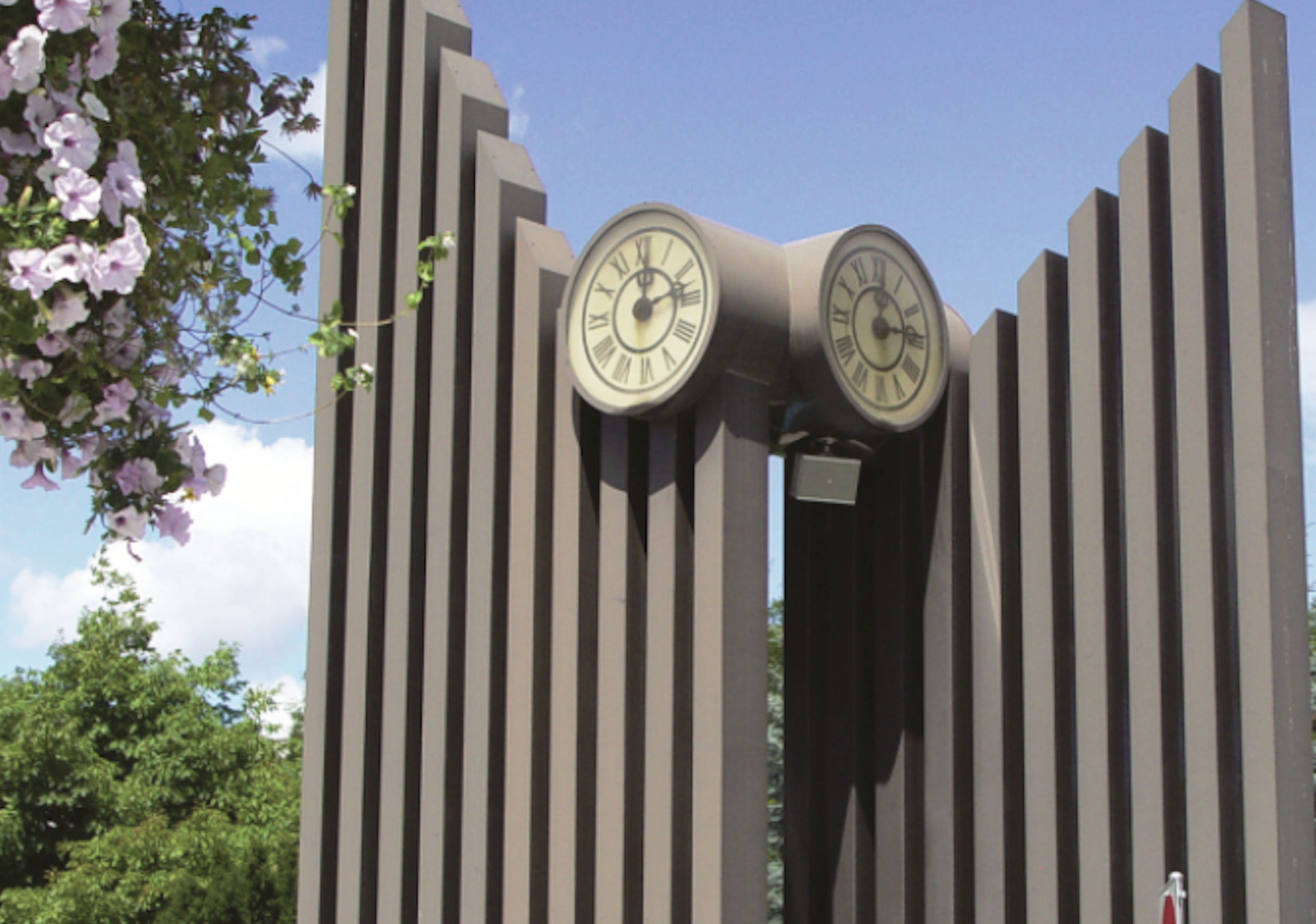 A clock tower sculpture on a sunny day.