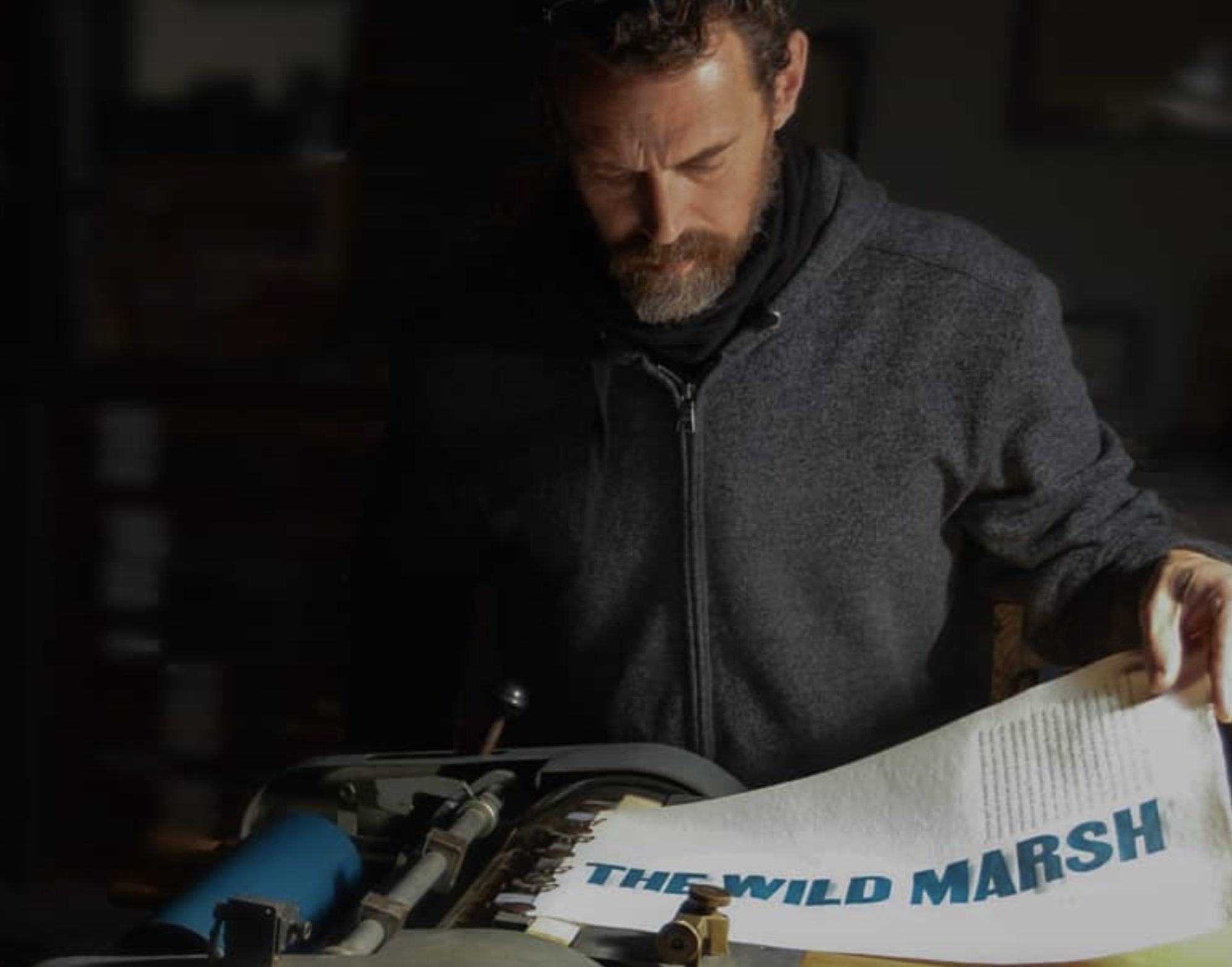 A guy in dramatic lighting print on a printing press.