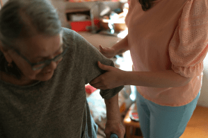 A caregiver assisting a senior woman at home.