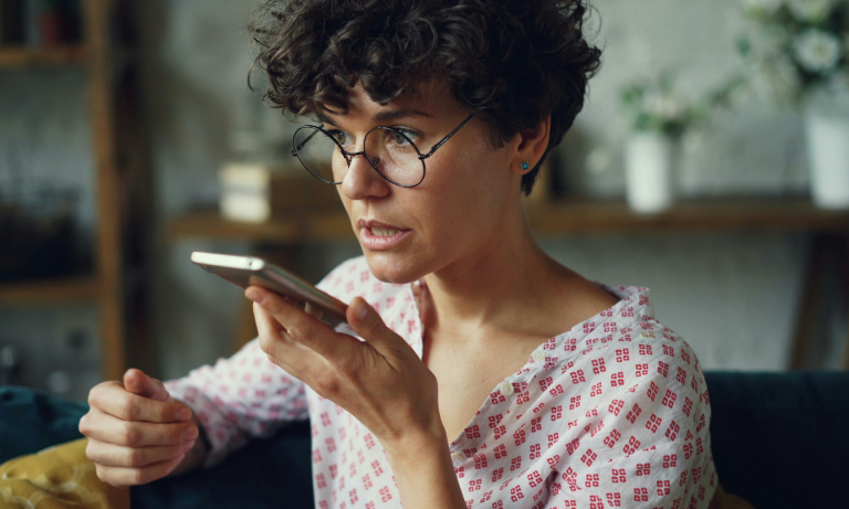 A woman wearing glasses talks on a cell phone.