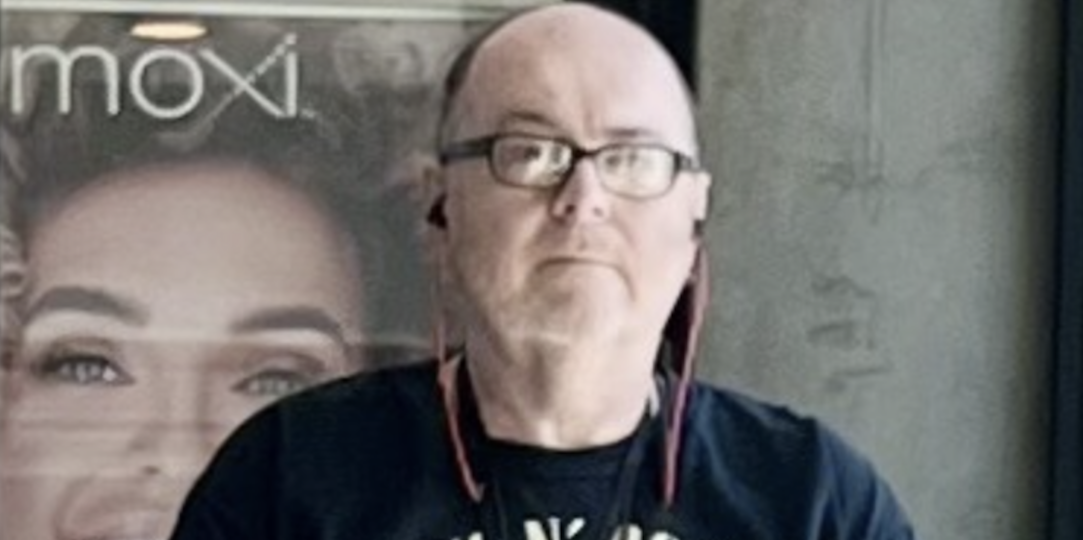 A man wearing glasses poses for a photo.