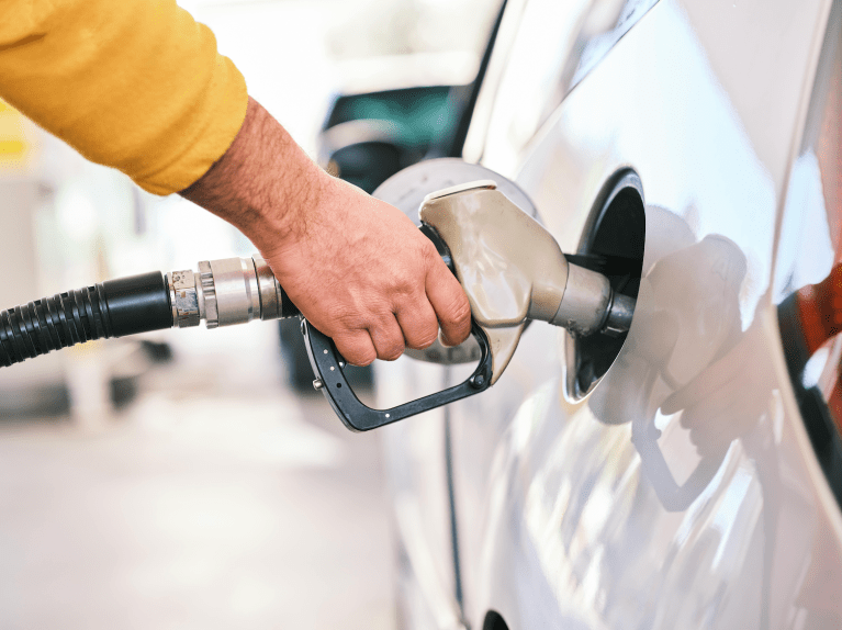A person pumps gas into their vehicle.