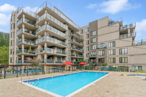 A pool outside an eight story condo building.