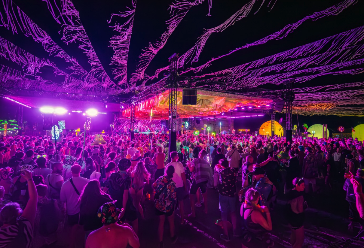 People dance under disco lights a music festival
