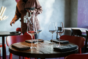 A table set for dinner at a restaurant with a server in the background.