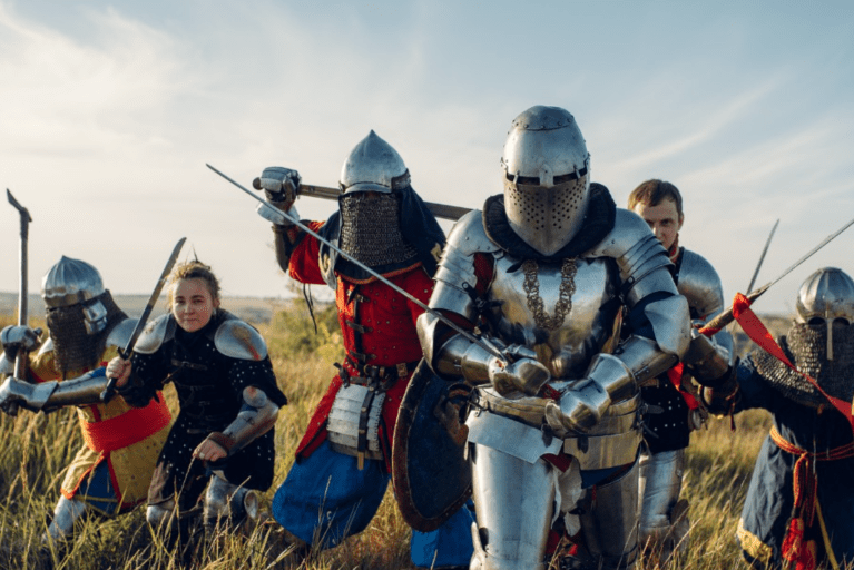 People dressed in period costumes including knights in armour.