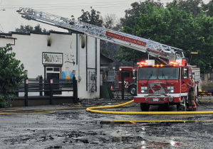 A fire truck with a ladder extended following a business fire.