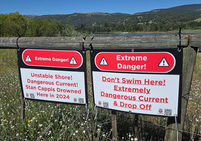 Signs warning the public not to swim in the river.