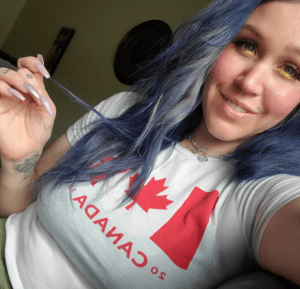 a woman wearing a canada t-shirt poses for a selfie.