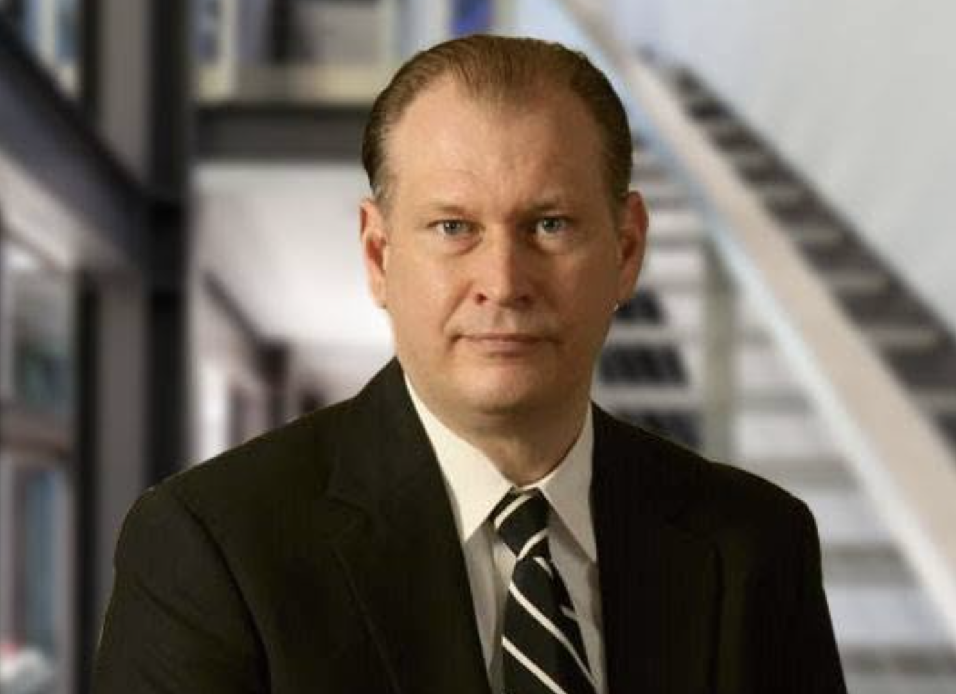 Head and shoulders shot of a man in a suit.