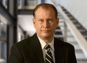 Head and shoulders shot of a man in a suit.