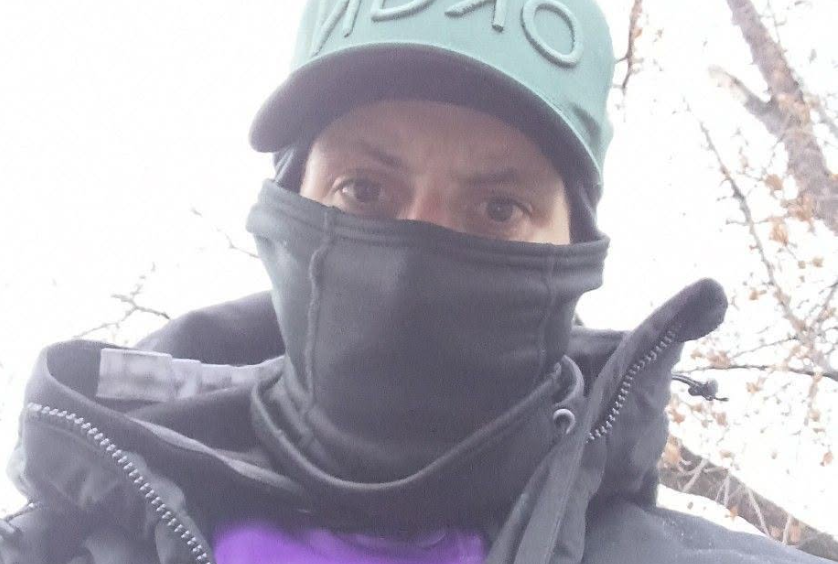 A man wearing a mask and a baseball cap.