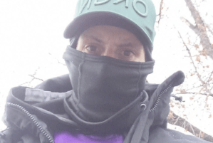 A man wearing a mask and a baseball cap.