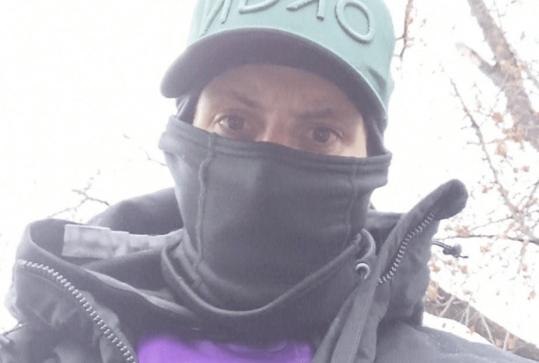 A man wearing a mask and a baseball cap.