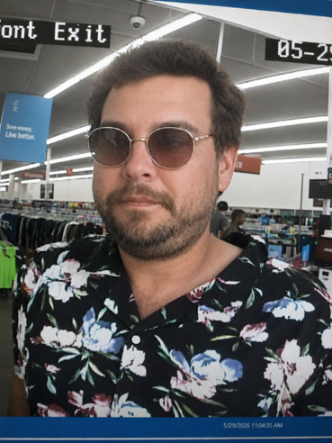 An image of a man wearing sunglasses and a floral shirt.