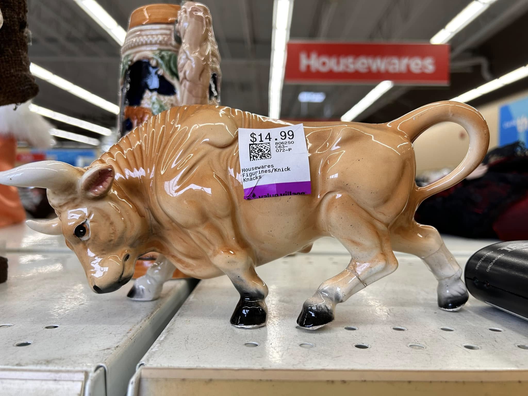 A bull figure with a glued on leg has price tag of $14.99 on it.