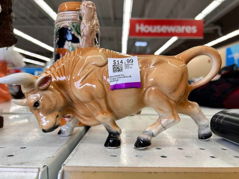 A bull figure with a glued on leg has price tag of $14.99 on it.