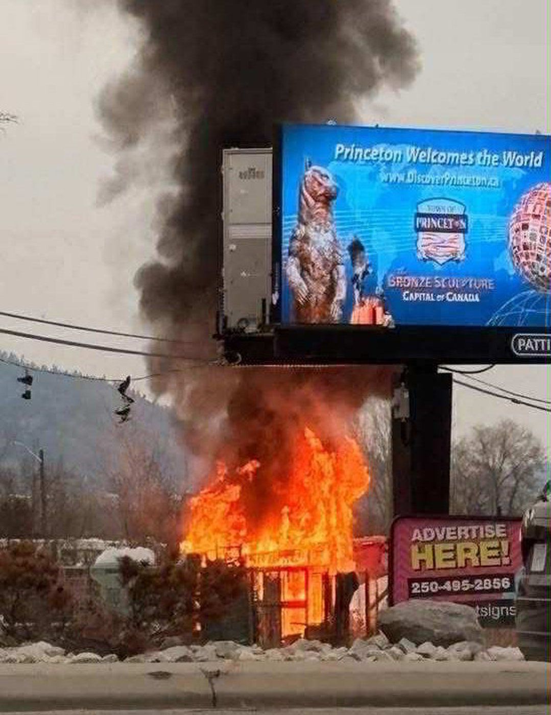 Flames and smoke can be seen from a fire at a homeless encampment.