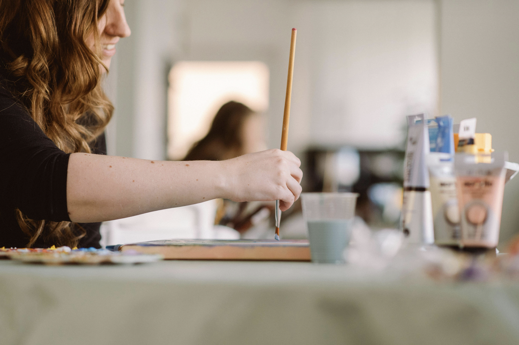 An artist paints with a brush and paint.