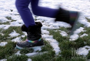 Person running through grass and snow.