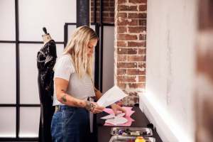 The picture shows a side profile of woman looking down at a sheet of paper in her hand.