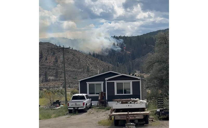 A small wildfire seen in the distance on a hillside.
