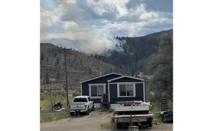 A small wildfire seen in the distance on a hillside.