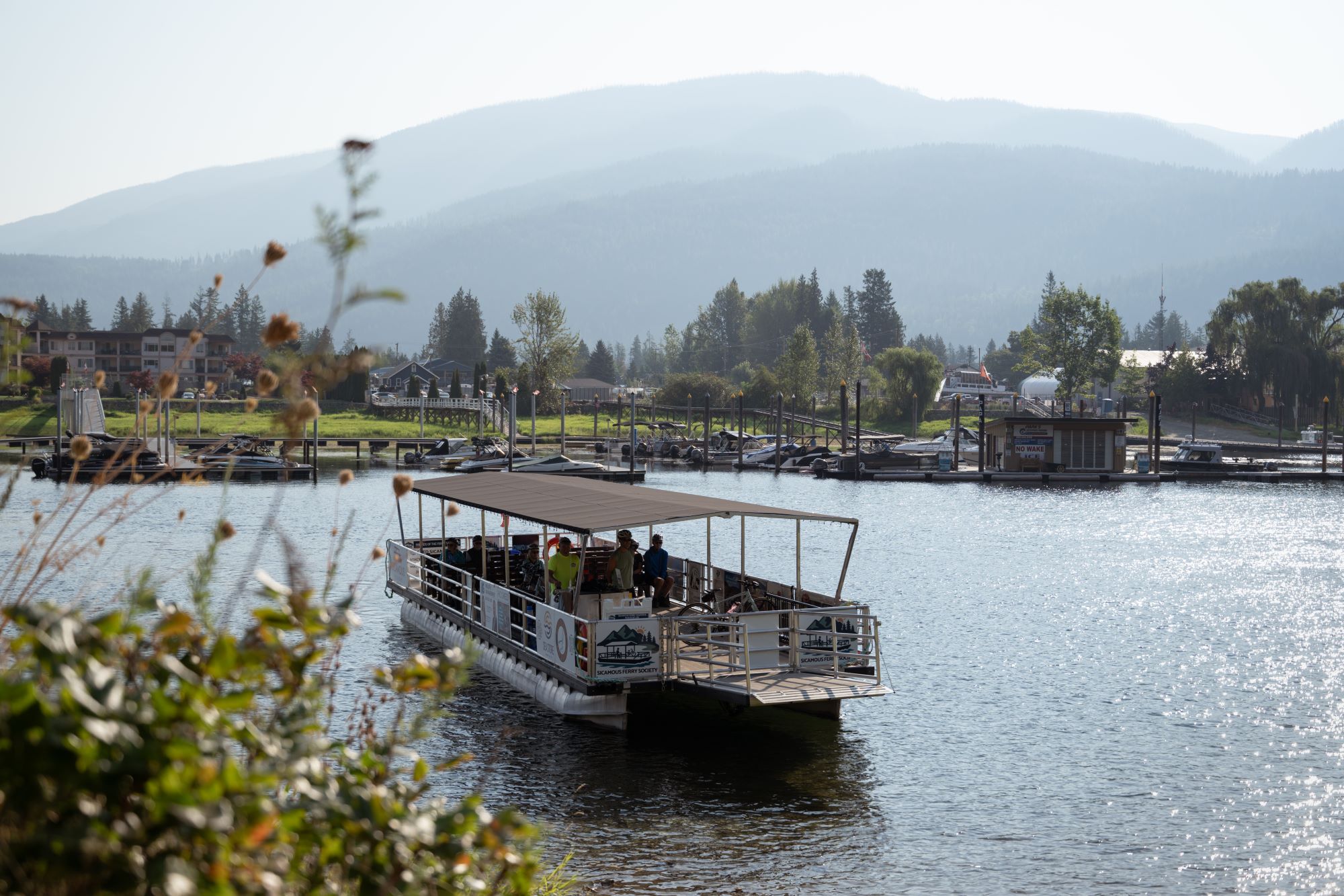 A small barge with a canopy shuttles people along a waterway.