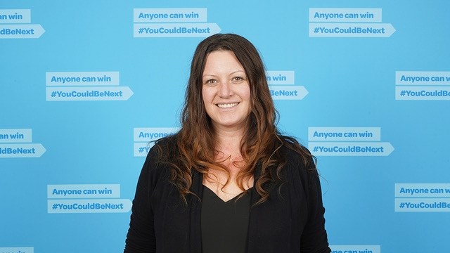 A woman smiling after winning the lottery.