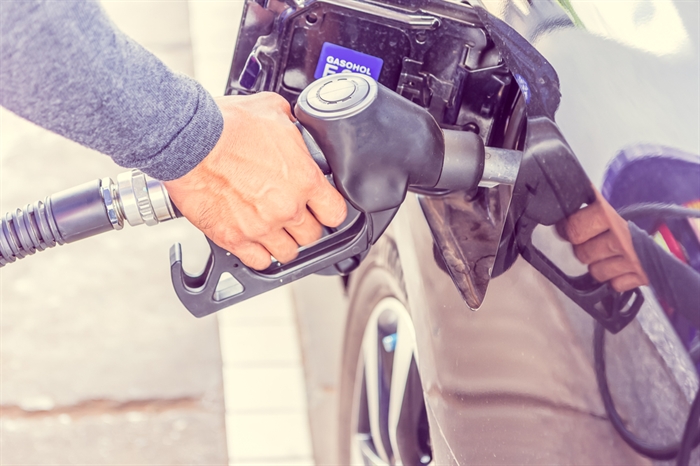 Someone pumping gas in their car close up.