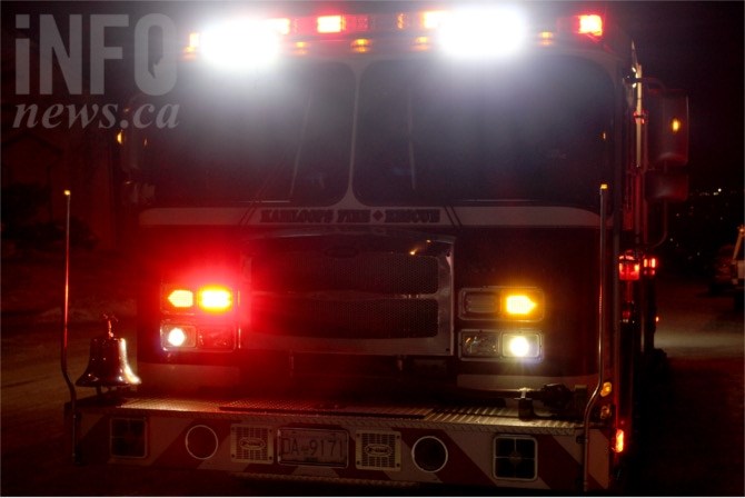 The front of a fire truck at night with emergency lights on.