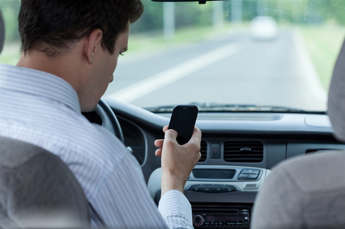 Man texting while driving a car
