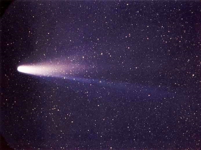 A bright ball of white light with a long glowing tail is seen against a black, starry sky.