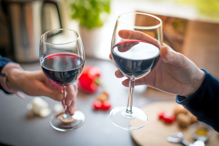Two people hold wine glasses.