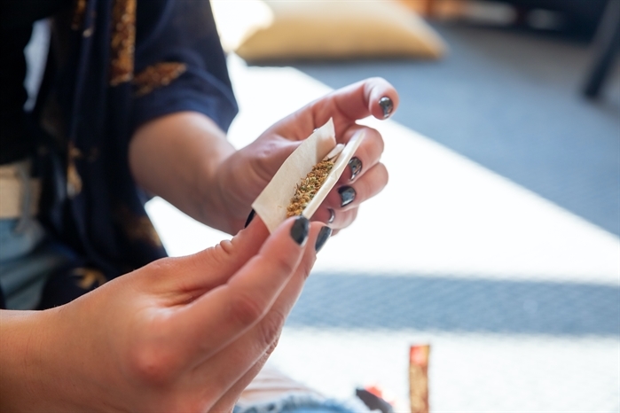 Two hands rolling up a doobie.