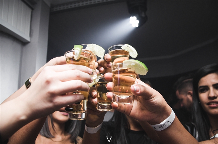 Bar patrons raise shot glasses